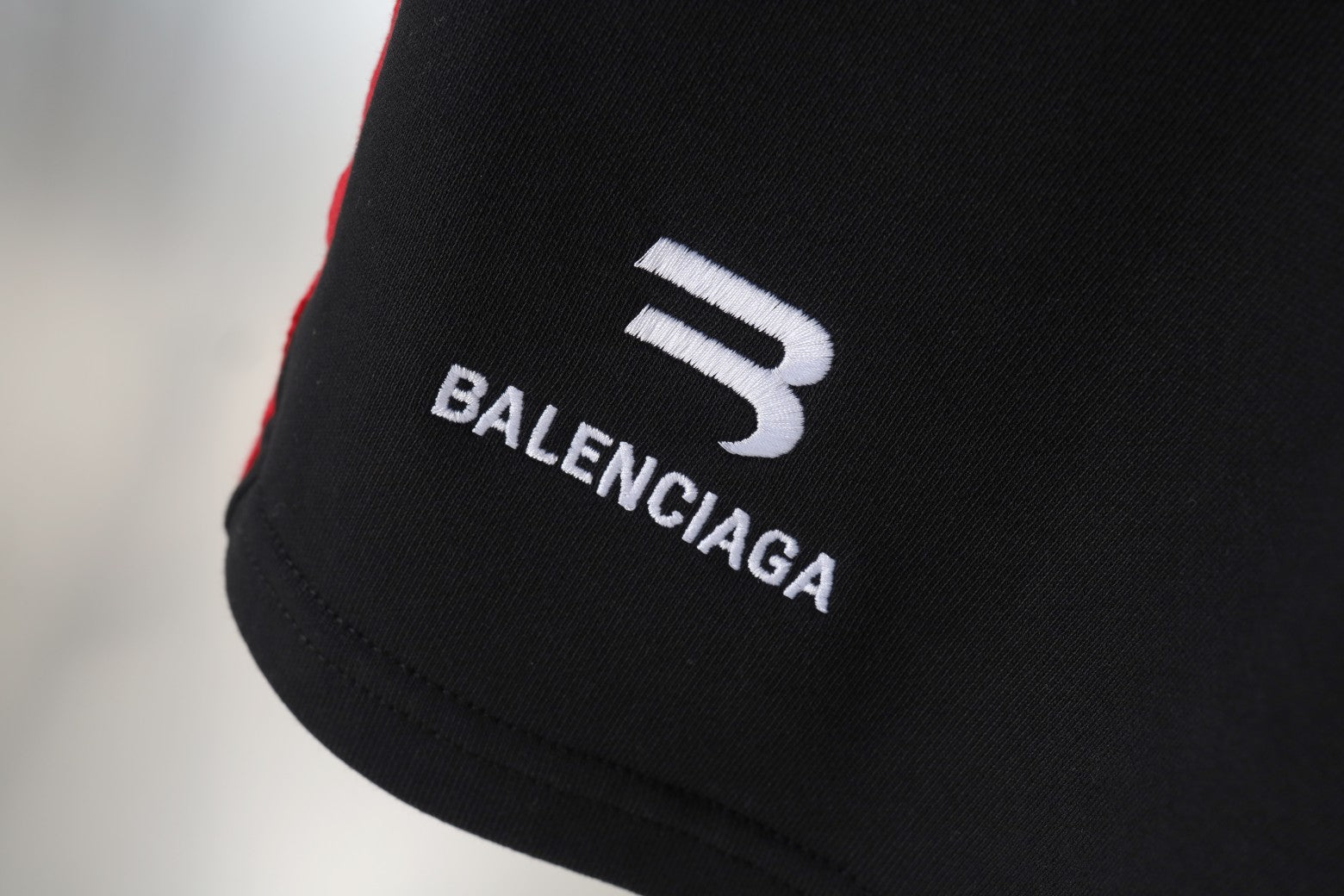 Balenciaga logo print on black shorts leg with white and red trim