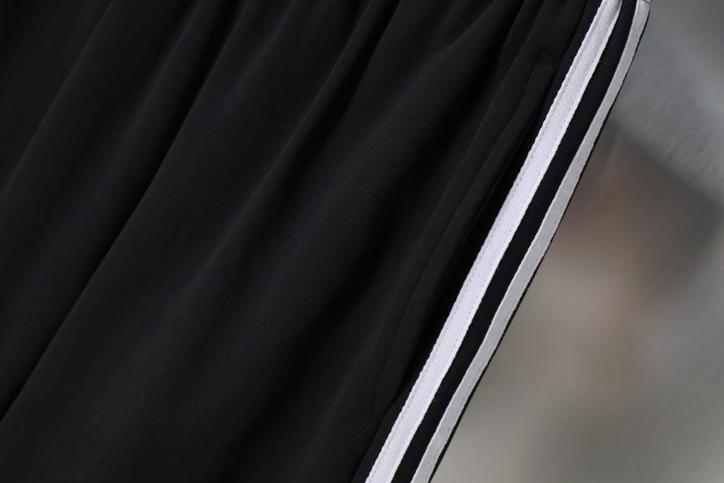 Black Balenciaga shorts leg with vertical white stripe and side seam trim