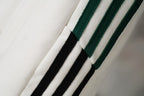 Close-up of white fabric with green and black triple stripe trim