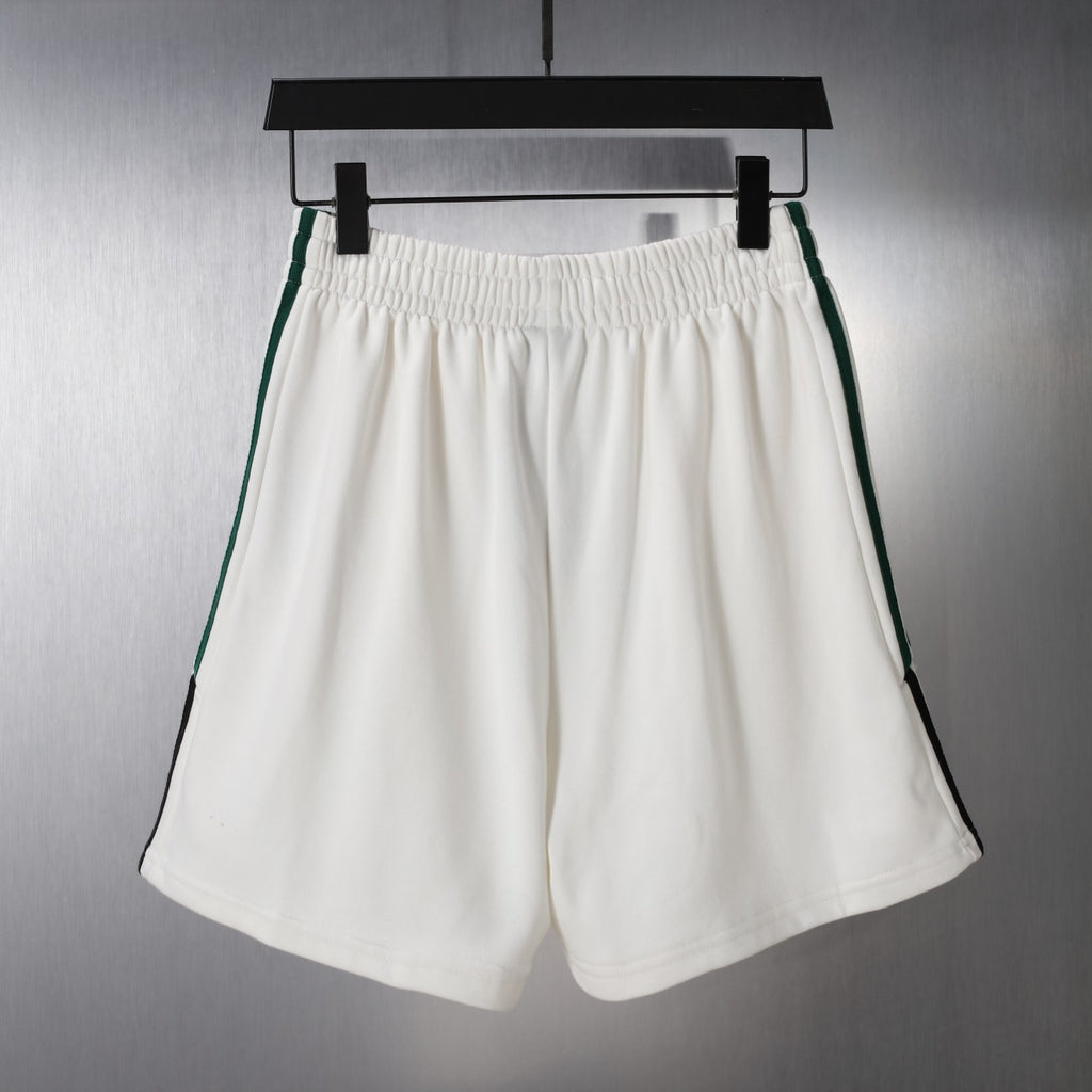 White shorts with elastic waistband and green/black side stripe trim