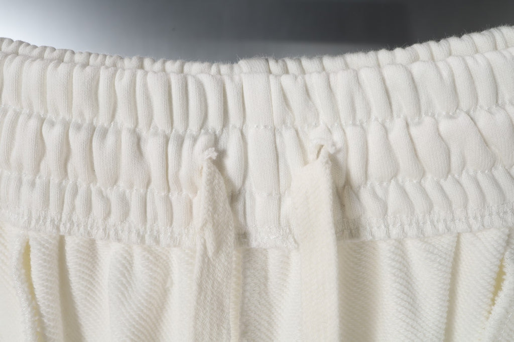 Smocked elastic waistband on white shorts with gathered fabric
