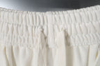 Smocked elastic waistband on white shorts with gathered fabric