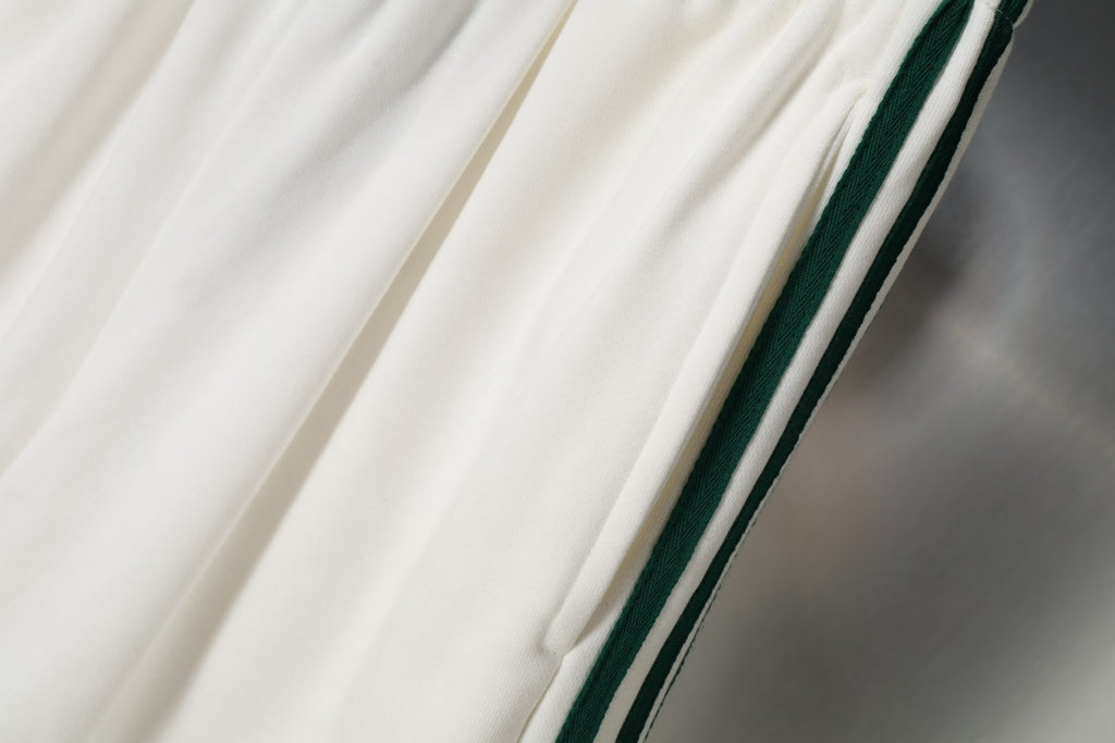 White shorts with diagonal green and black side stripe accents
