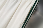 White shorts with diagonal green and black side stripe accents