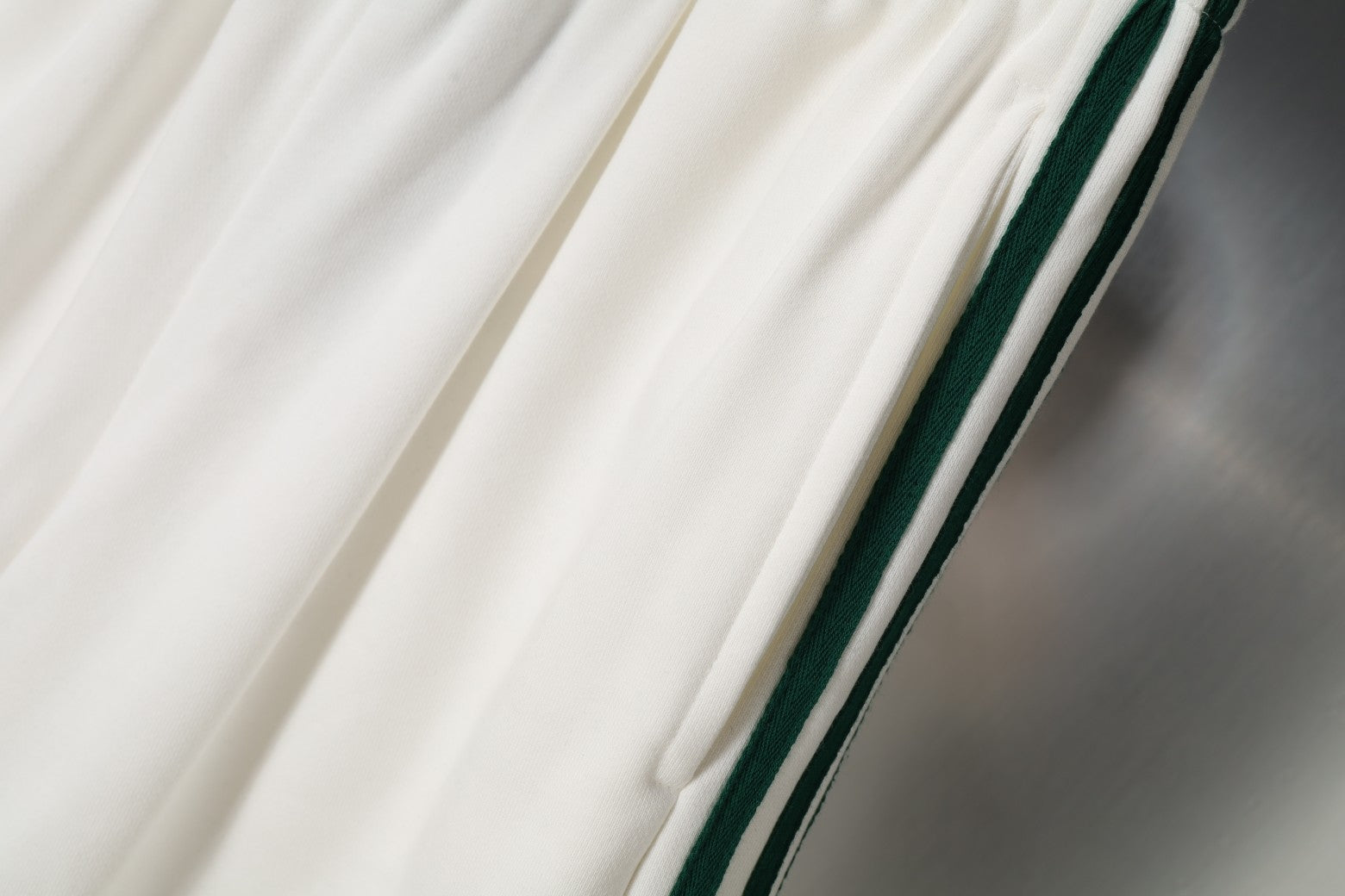 White shorts with diagonal green and black side stripe accents