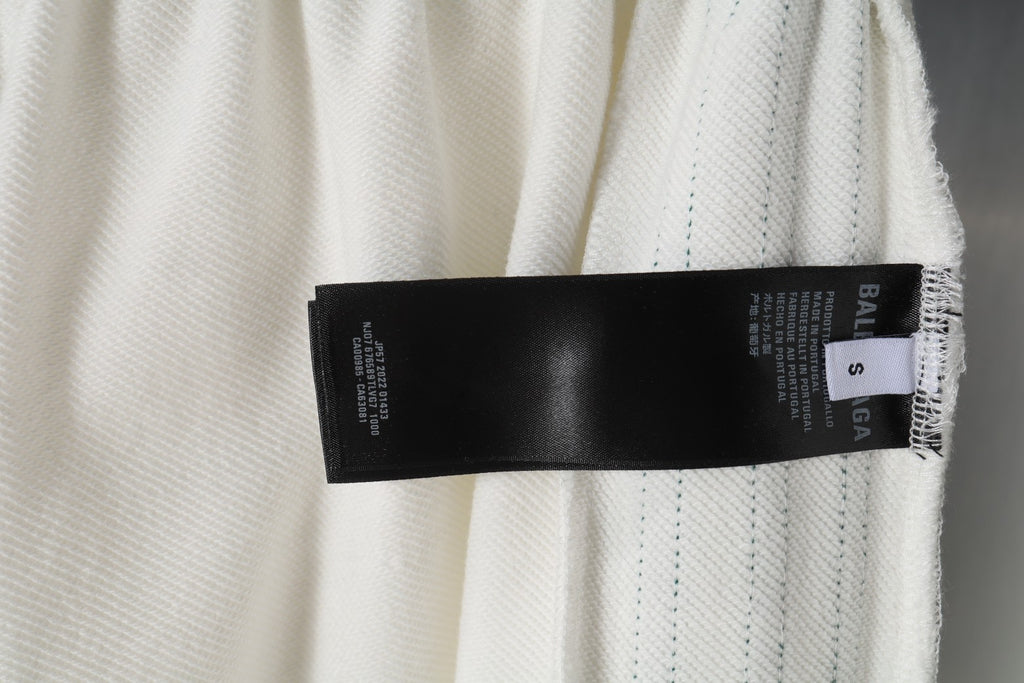White shorts with black care label and size tag at hem