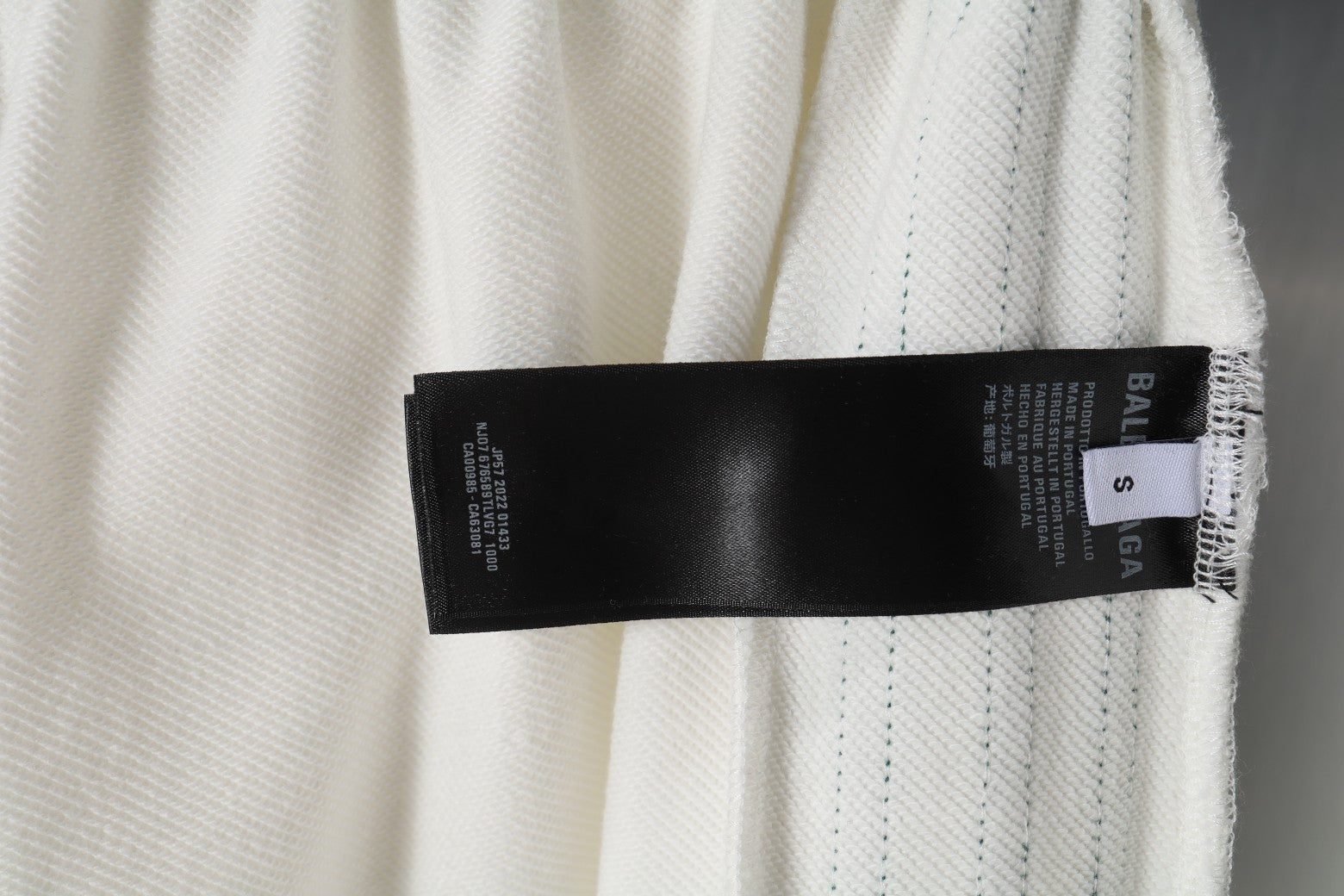 White shorts with black care label and size tag at hem
