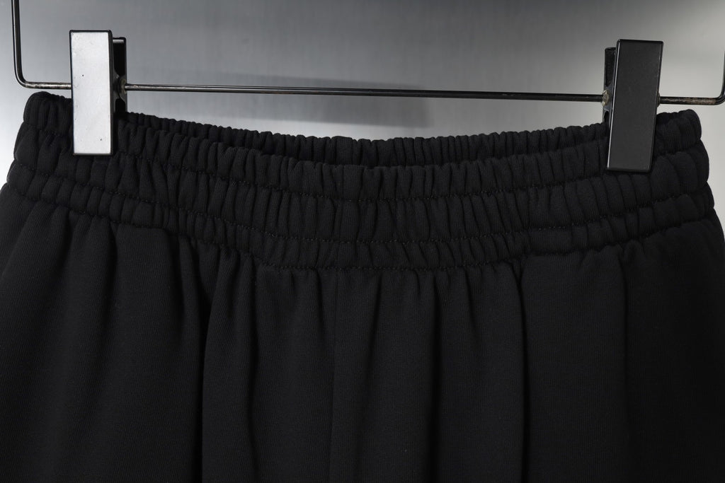 Balenciaga black shorts viewed from above on hangers with elastic waistband
