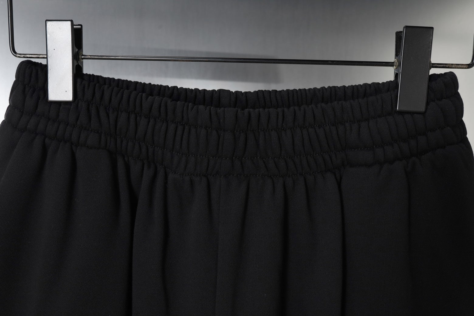 Balenciaga black shorts viewed from above on hangers with elastic waistband