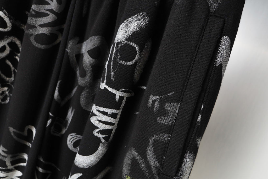 Black pants with side pocket opening and vertical graphic print