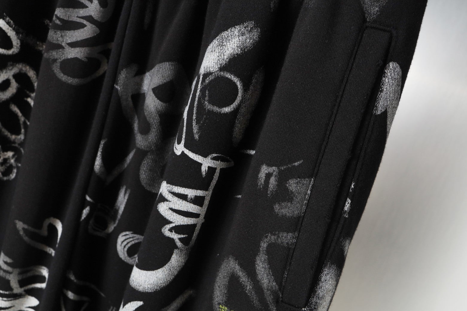 Black pants with side pocket opening and vertical graphic print