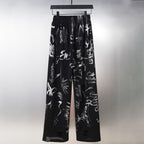 Black wide-leg pants with allover white signature-style graphic print