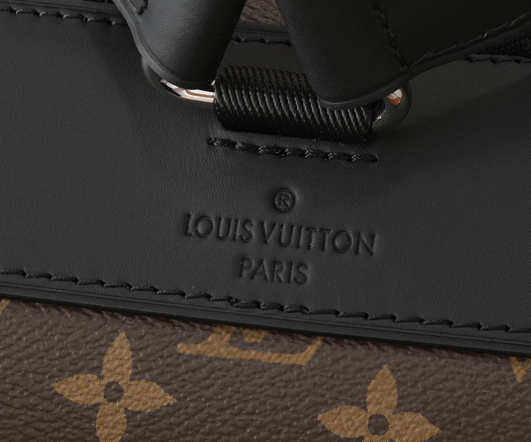 Monogram backpack close-up of embossed “LOUIS VUITTON PARIS” on leather