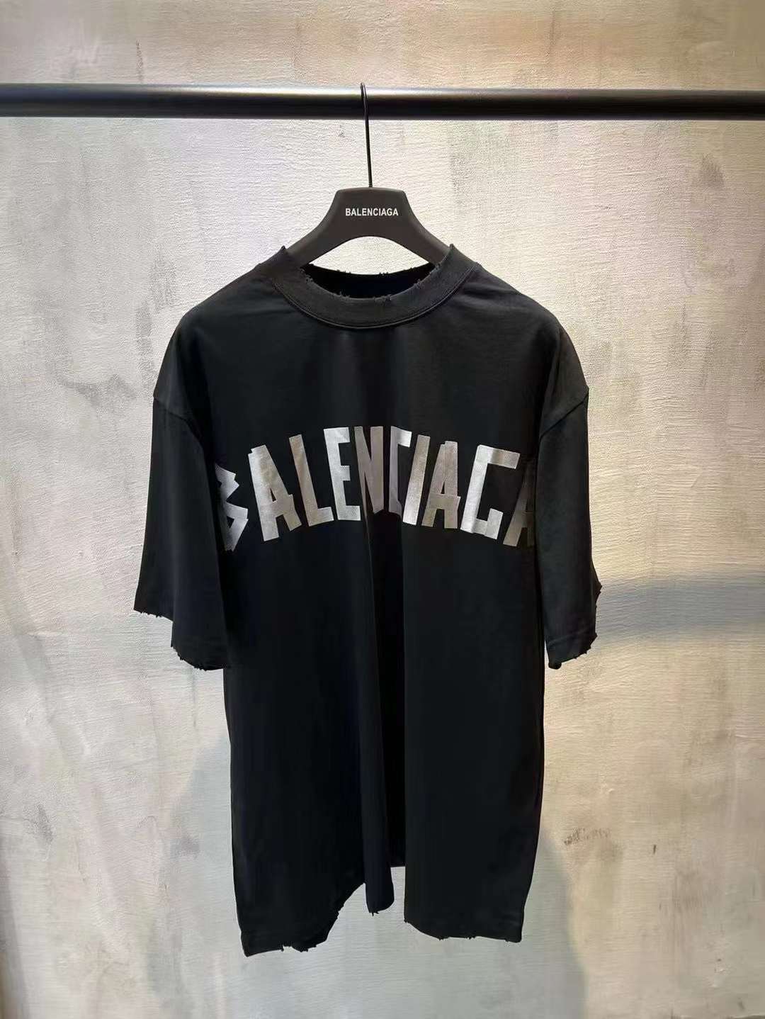 Black short-sleeve T-shirt with large white BALENCIAGA logo across front