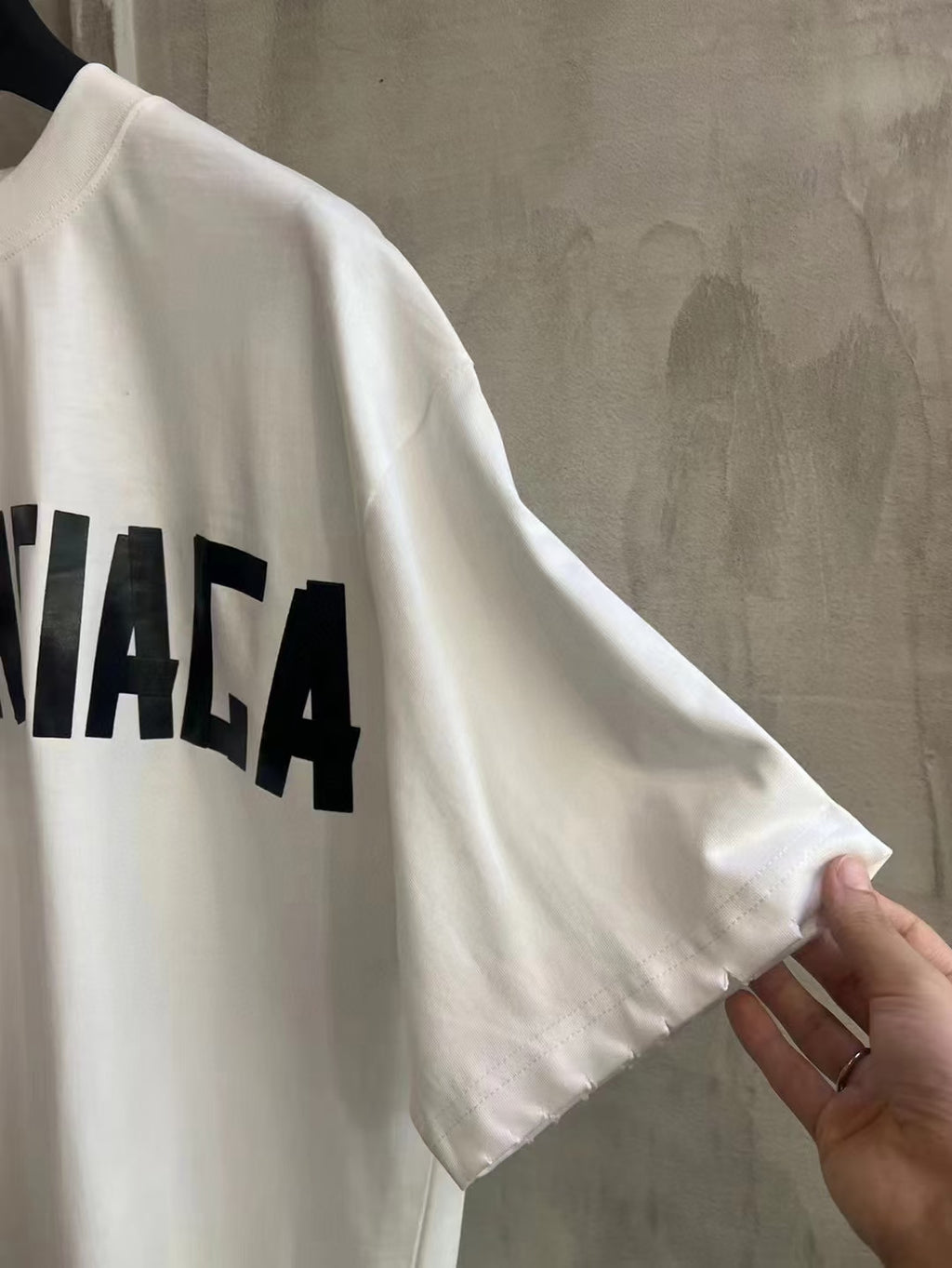 White short-sleeve T-shirt with partial Balenciaga logo on sleeve