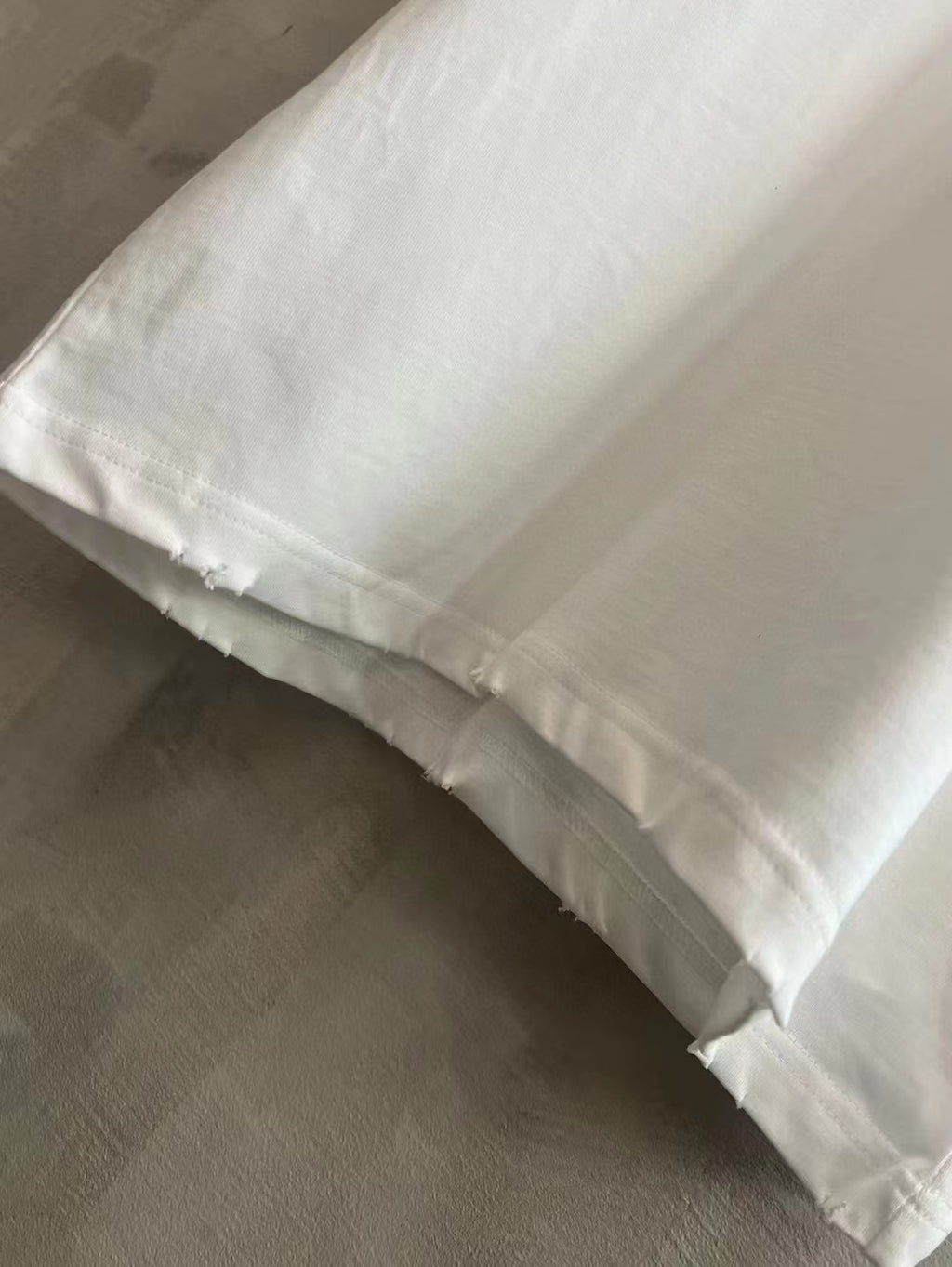 White T-shirt hem with slight frayed edge