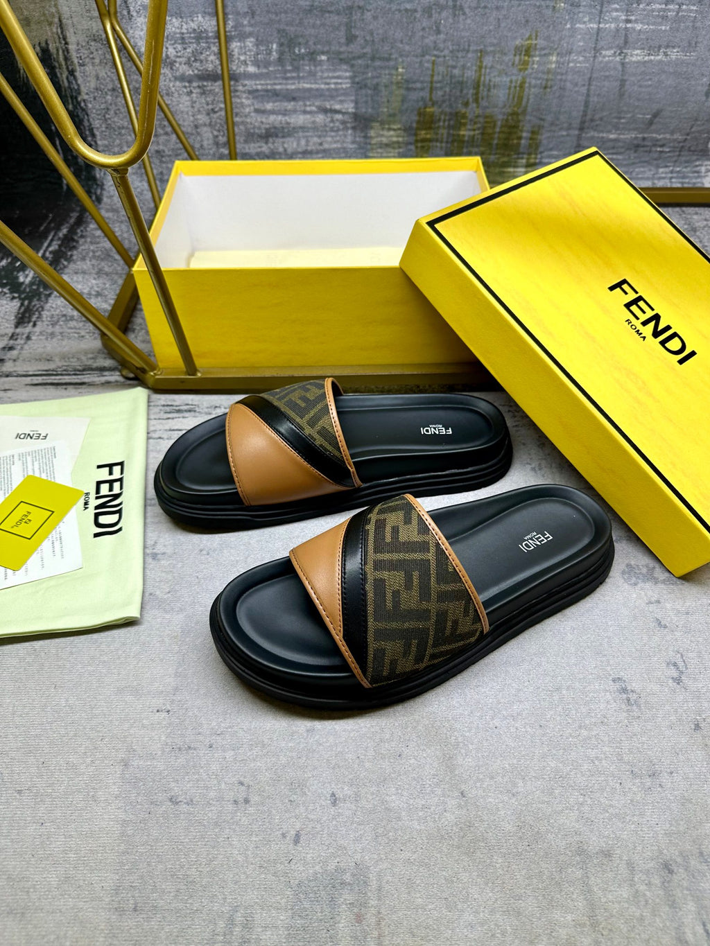 Pair of black Fendi slide sandals with FF monogram band and tan leather edging