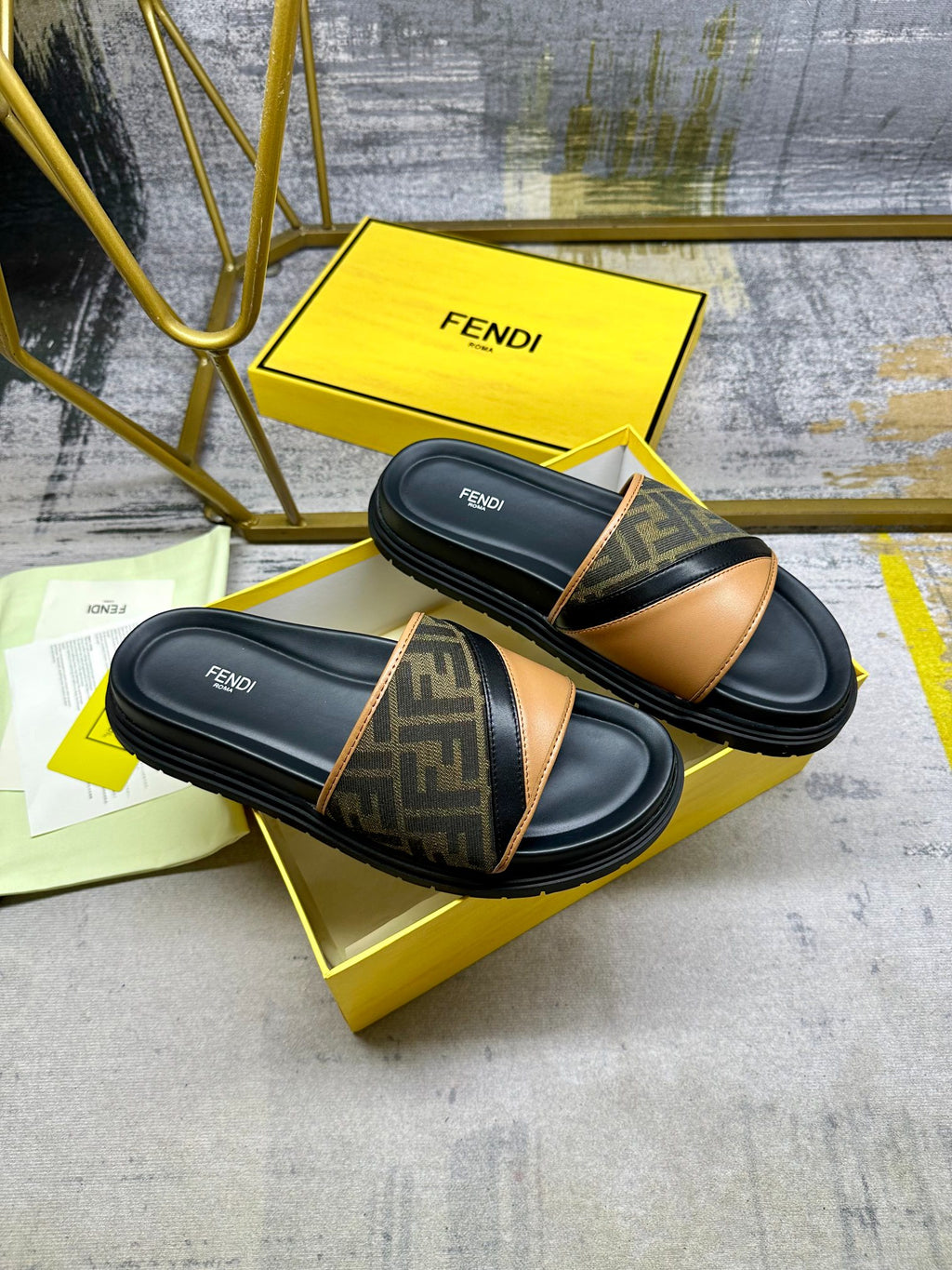 Black Fendi slides with FF monogram straps and tan leather across the top