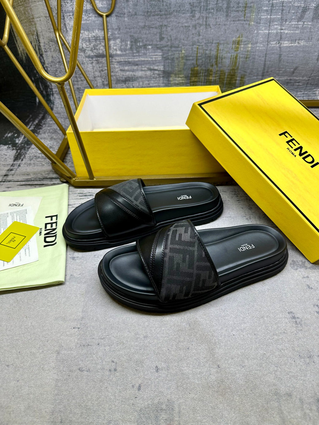 Black Fendi slide sandals with FF-pattern straps and thick rubber sole, pair view.