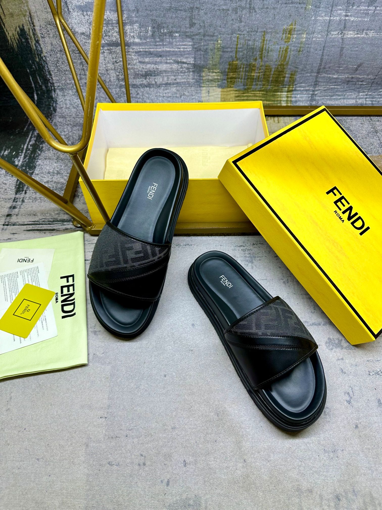 Black Fendi slide sandals with FF-pattern upper and cushioned footbed, angled pair.