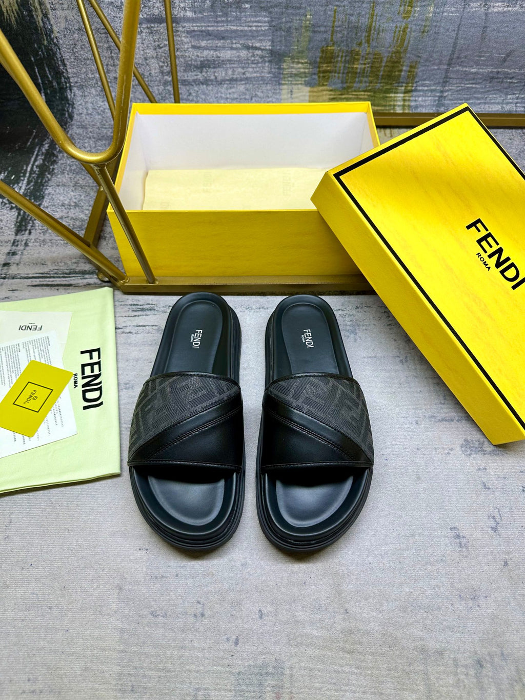 Black Fendi slide sandals with FF logo strap and rounded toe, front pair.