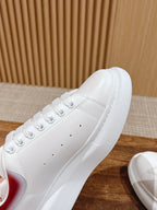 Close-up of white sneaker upper with perforated toe and lace eyelets.