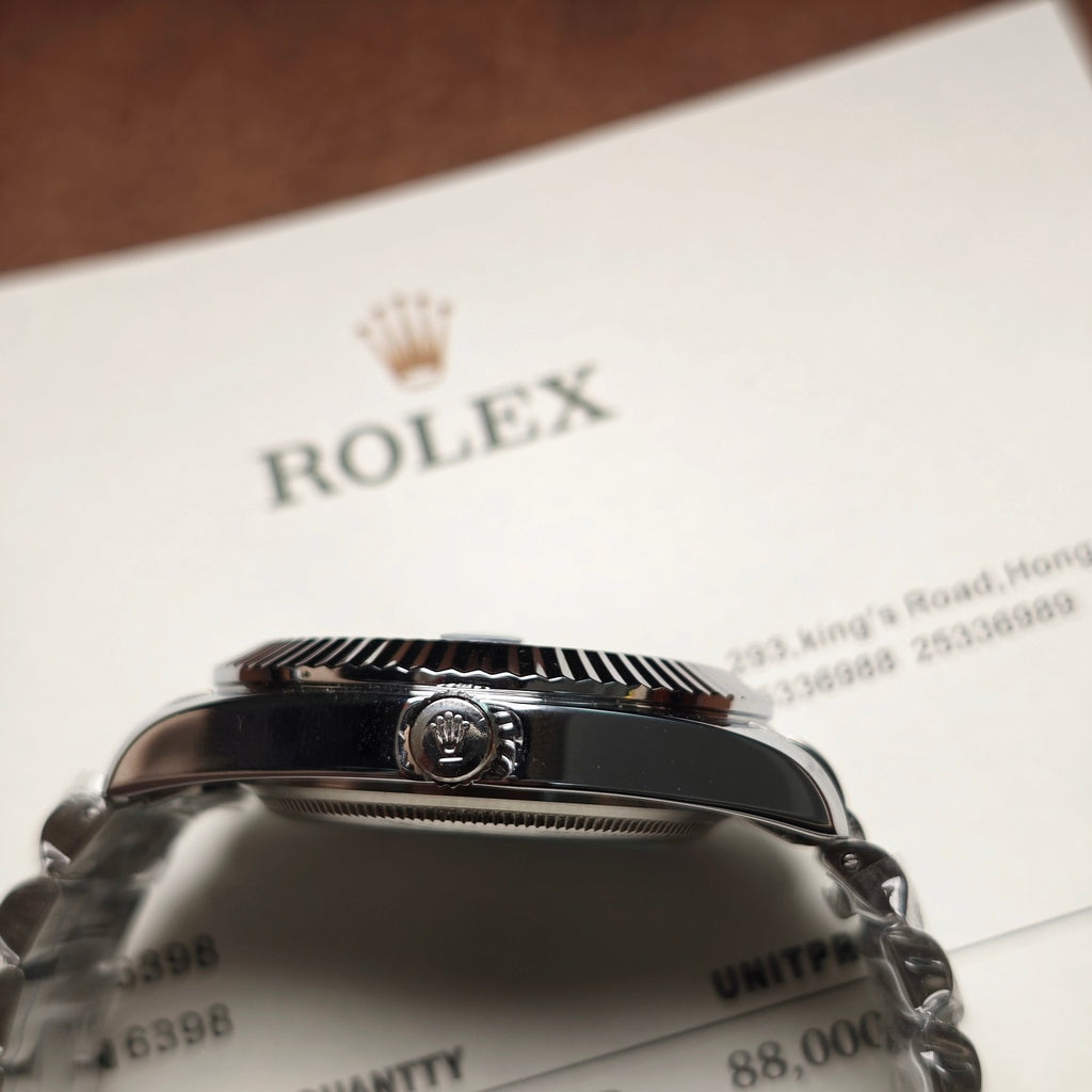 Rolex wristwatch crown and case close-up with dark caseback and metal bracelet
