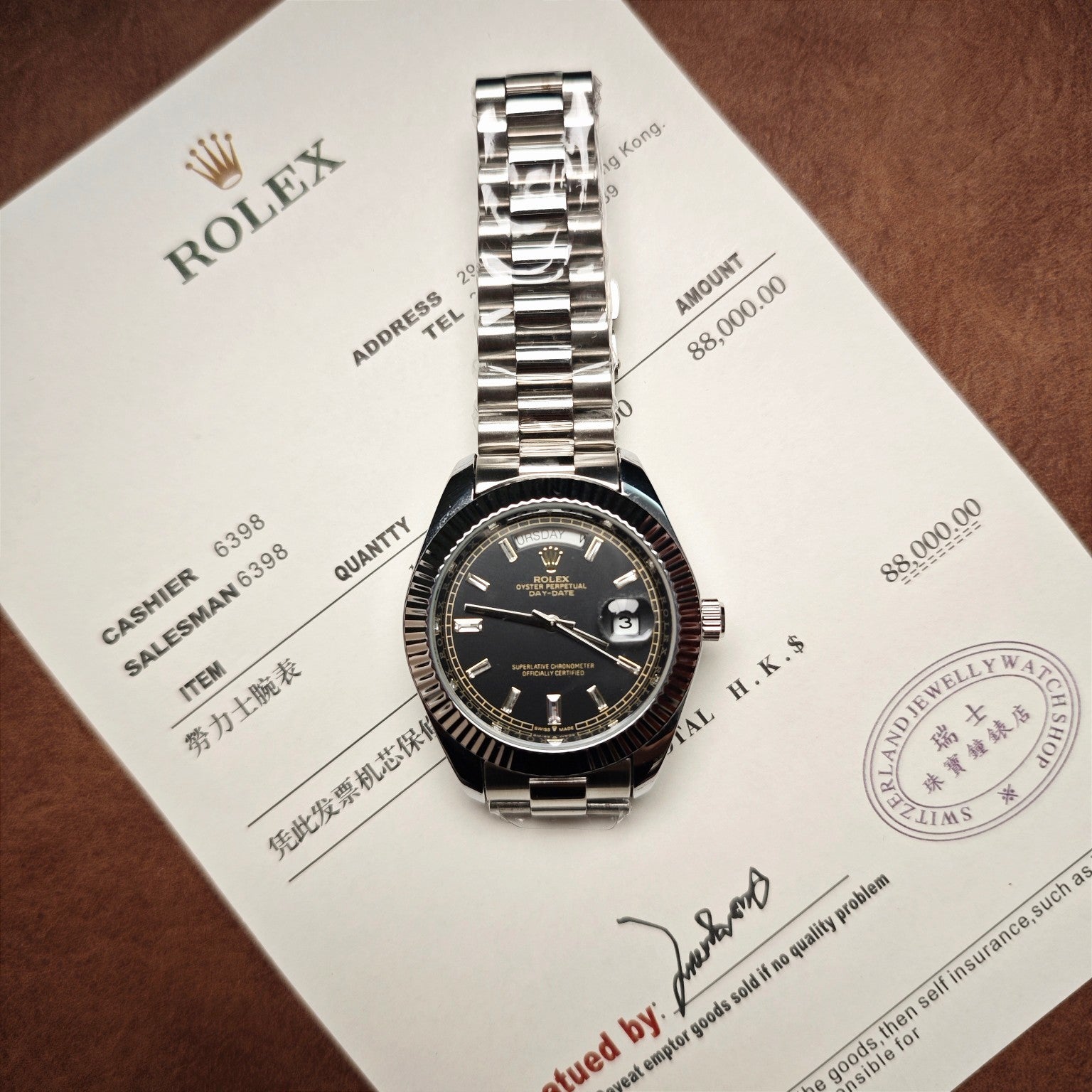Rolex wristwatch with silver-tone bracelet on certificate card, black dial and date display