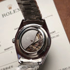 Rolex wristwatch open caseback view showing mechanical movement, on paperwork
