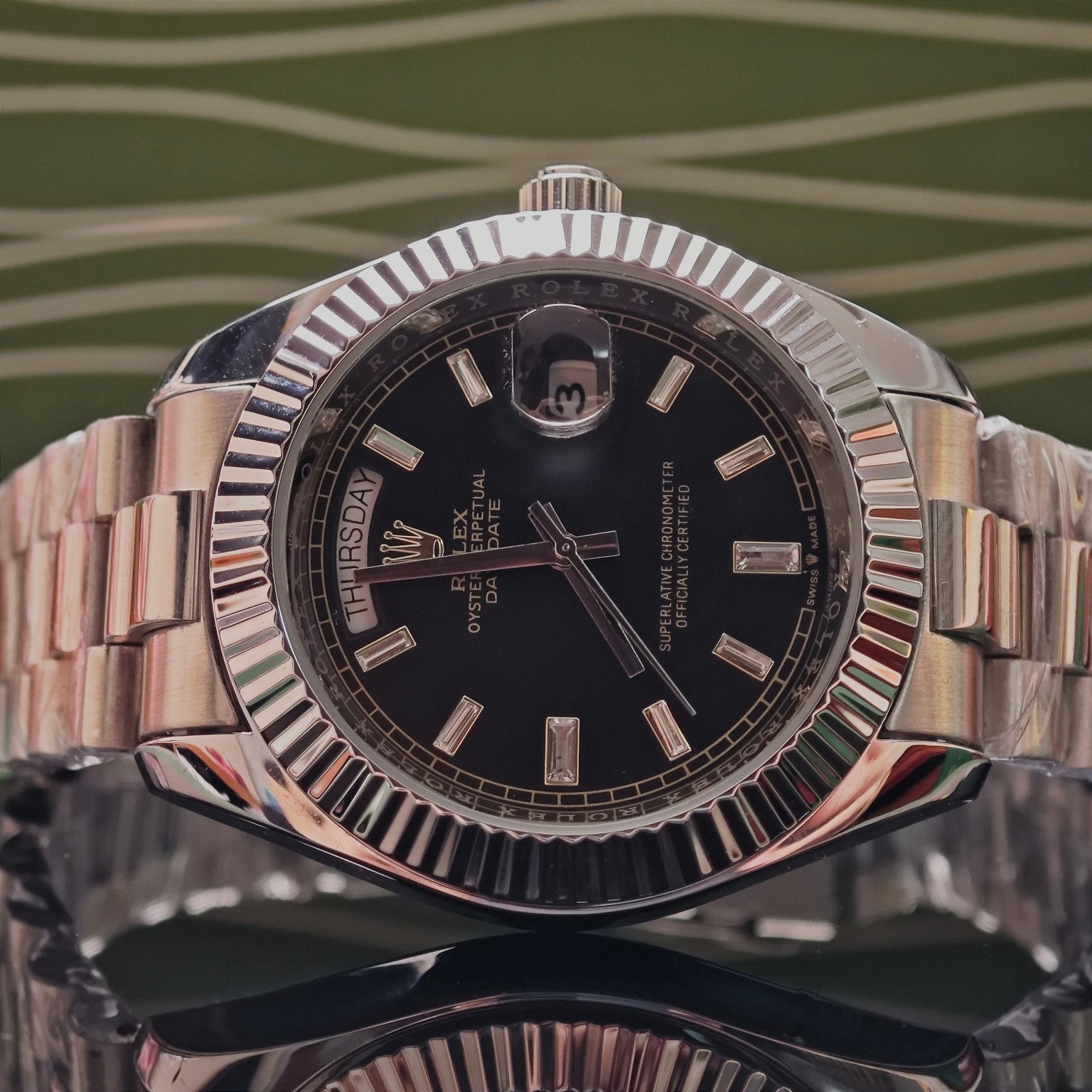 Rolex Day-Date wristwatch with black dial and silver-tone metal bracelet, date window at 3