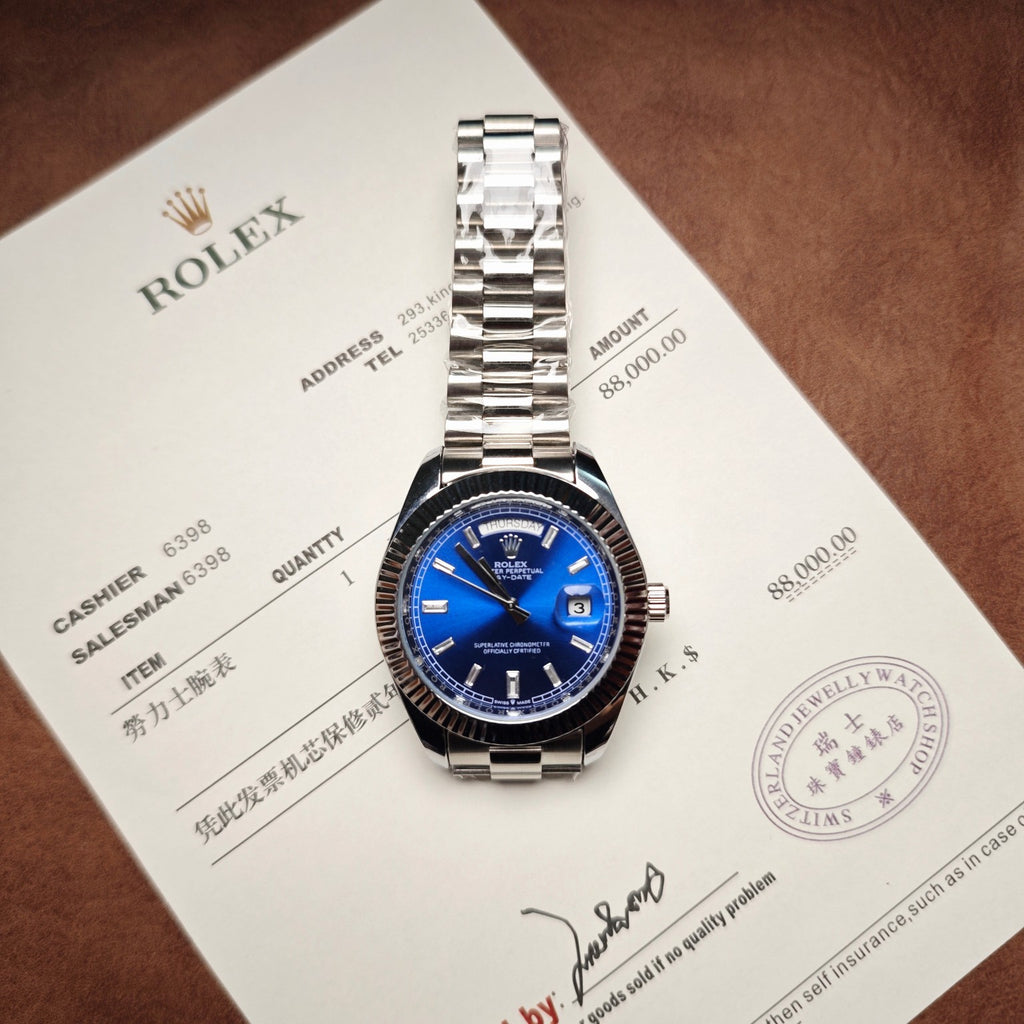 Stainless steel Rolex wristwatch with blue dial and date window on document