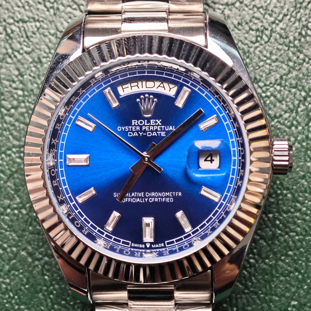 Rolex day-date wristwatch with blue dial reading FRIDAY and date window at 4