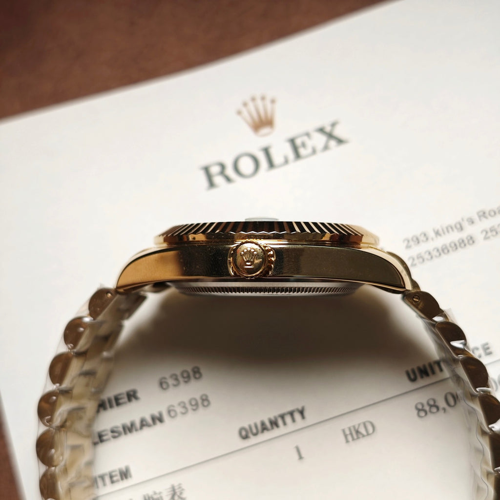 Gold-tone Rolex watch case with crown, engraved bezel, metal links