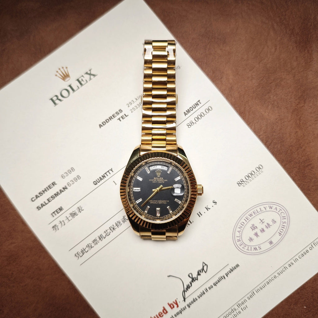 Gold-tone Rolex Oyster watch with black dial, metal bracelet, on invoice paper