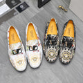 Patterned slip-on loafers with black, cream, and gold motif; buckle strap detail