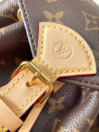 Louis Vuitton monogram bag close-up of tan leather buckle tab and gold clasp