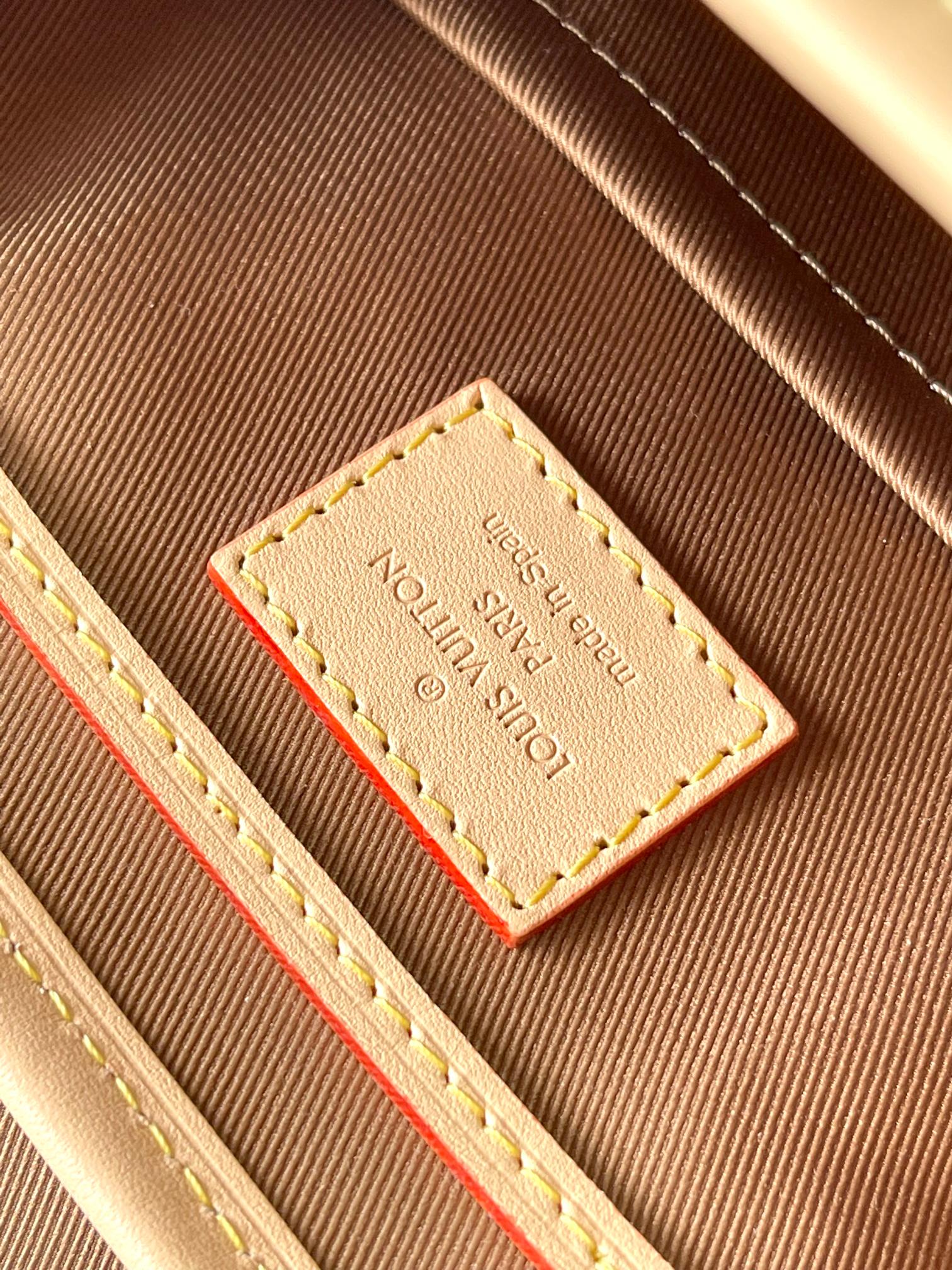 Louis Vuitton monogram bag interior close-up of stitched label and red accent stripe