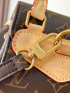 Louis Vuitton monogram bag strap hardware with tan leather tab and stitched logo patch