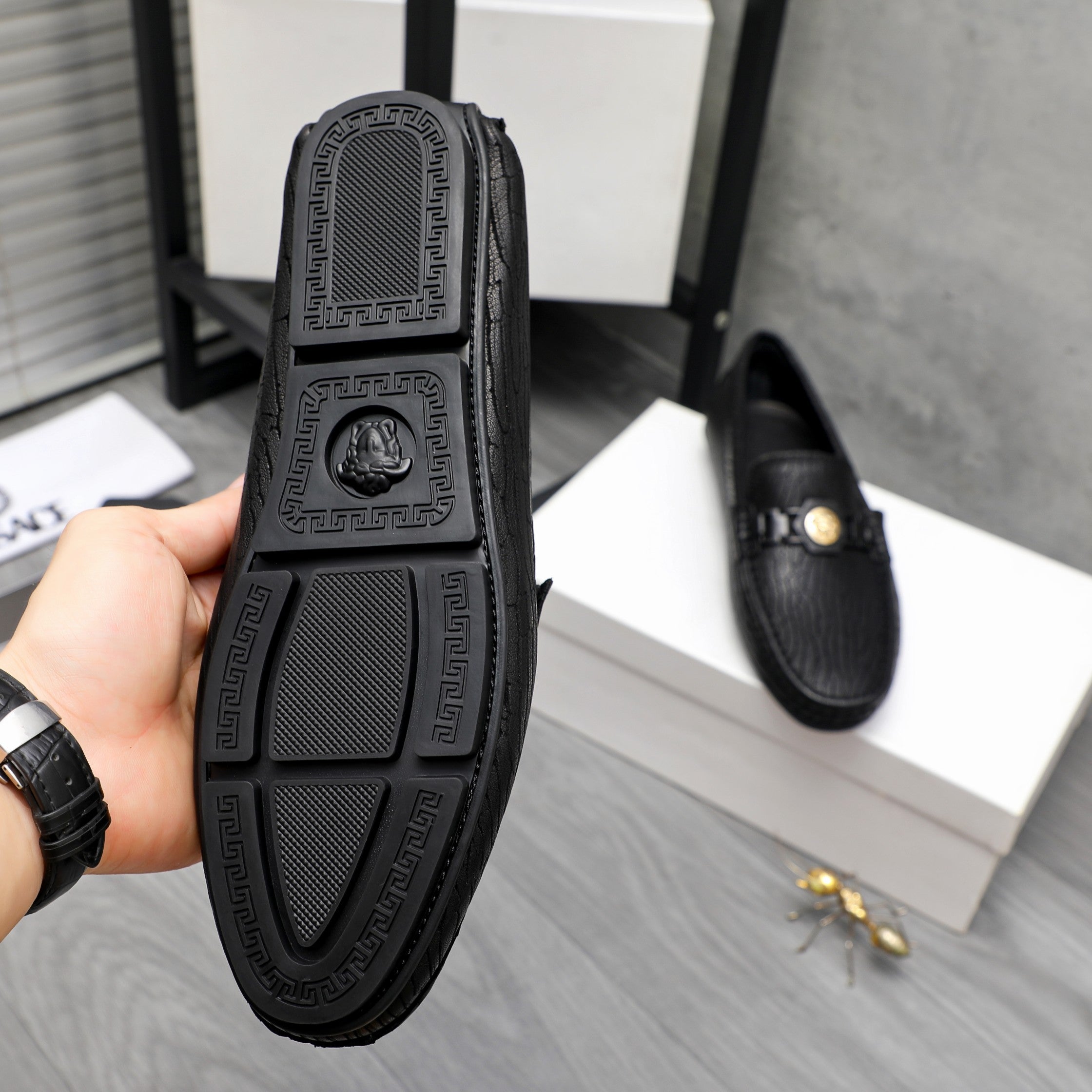 Versace luxury loafer outsole, black textured tread with logo pattern
