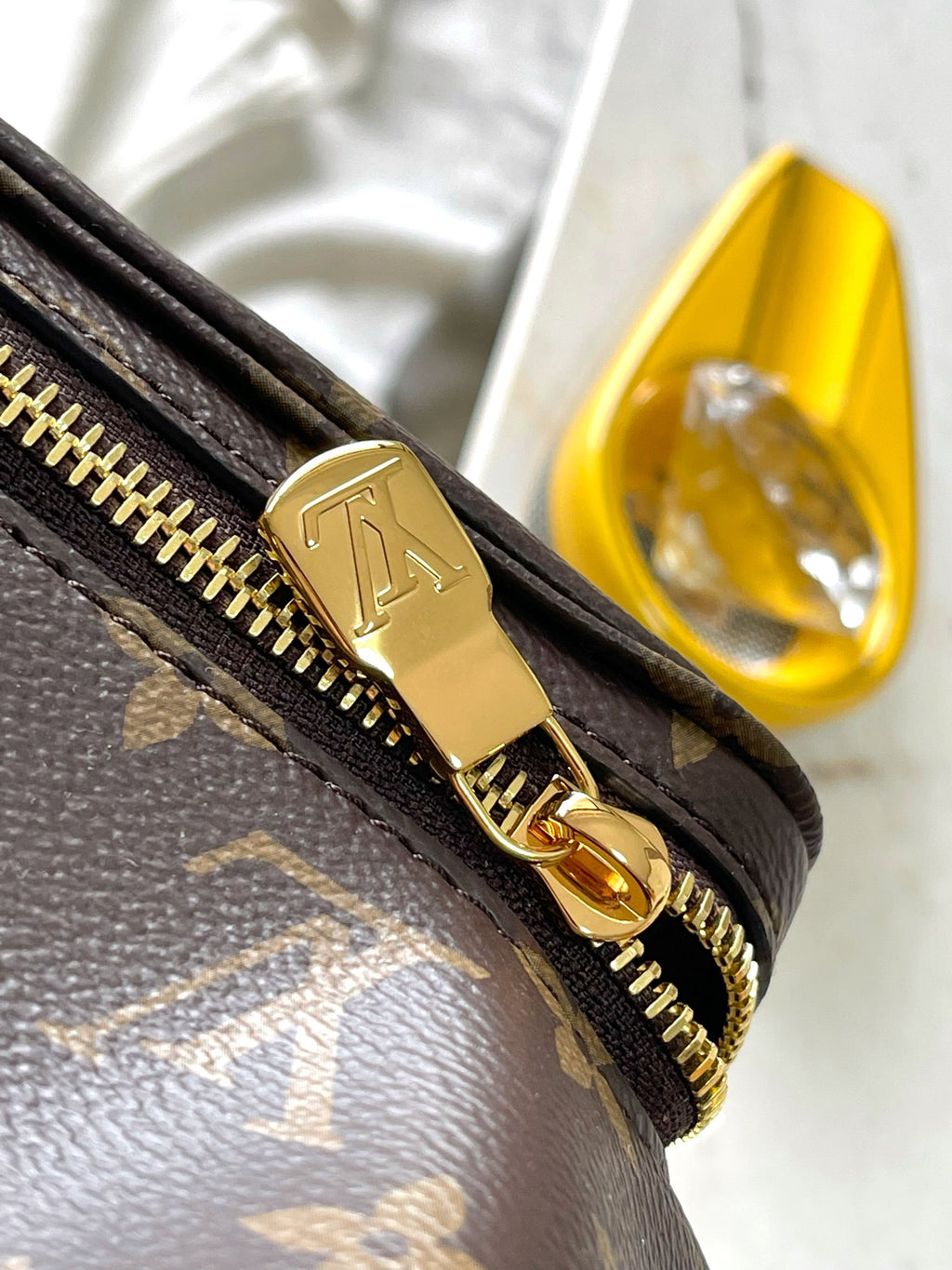 Monogram canvas pouch with gold-tone zipper pull and hardware ring detail