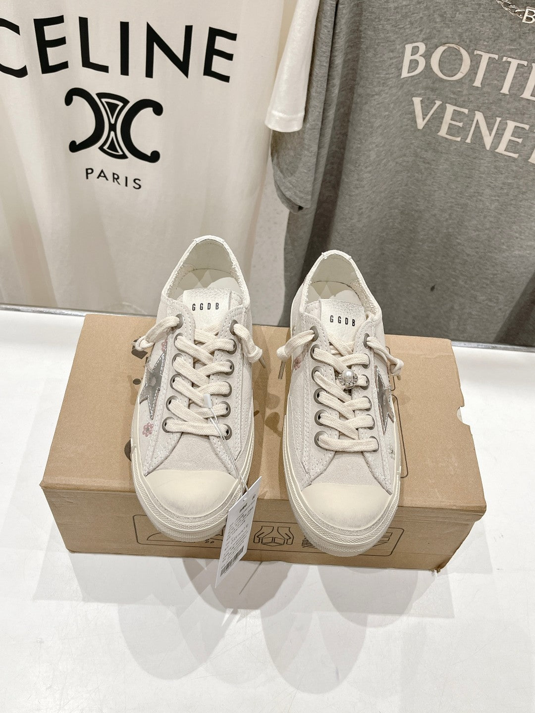 Luxury shoes by Golden Goose: light beige low-top sneakers, lace-up pair on shoe box