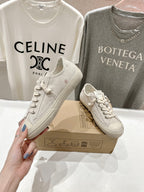 Pair of white low-top sneakers with lace-up closure and star accent