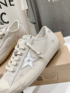 White low-top sneakers with star patch on the side and lace-up front