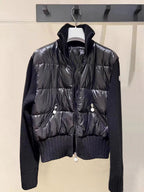 Moncler dark puffer jacket with knit sleeves, zip front, snap flap pockets.