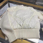 Moncler white puffer jacket flat lay, MONCLER logo on chest, knit ribbed hem.