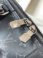 Louis Vuitton metal zipper pulls on dark monogram bag, close-up of hardware and leather