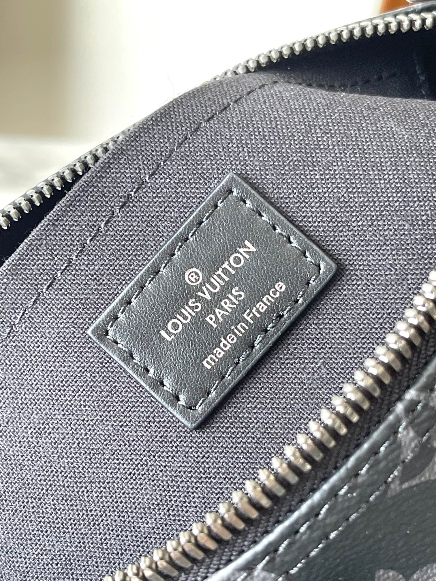 Louis Vuitton Paris leather label patch on monogram bag near zipper pull
