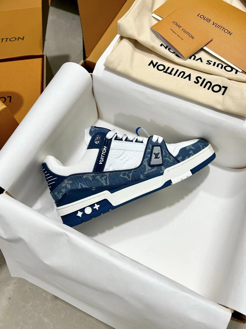 Louis Vuitton trainer shoes, side profile with navy heel and LV emblem