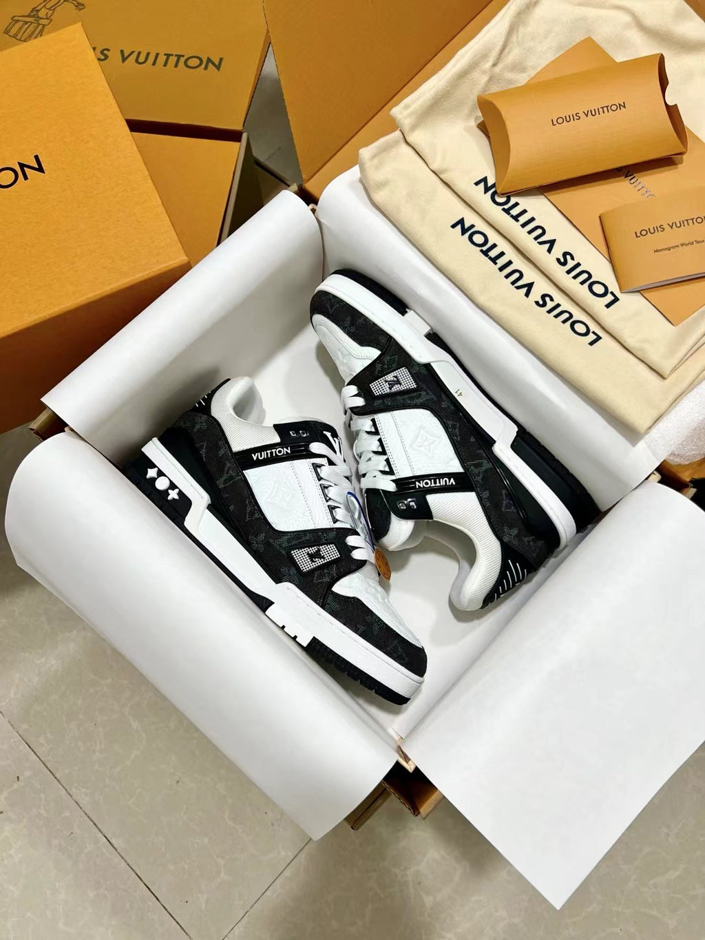 Low-top trainer sneakers pair, white and black with LV branding on heel and sides