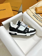 Low-top trainer sneakers side view, black and white uppers with LV logo badge